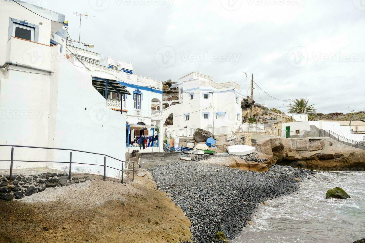 a beach with white buildings and a rocky shore photo