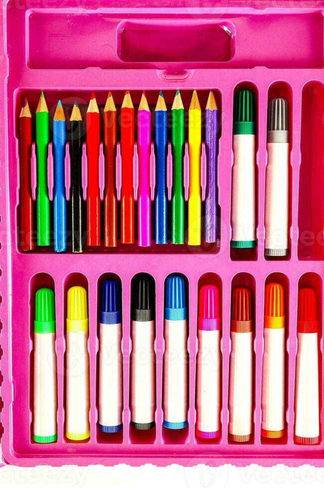 a pink case with a variety of colored pencils and pens photo