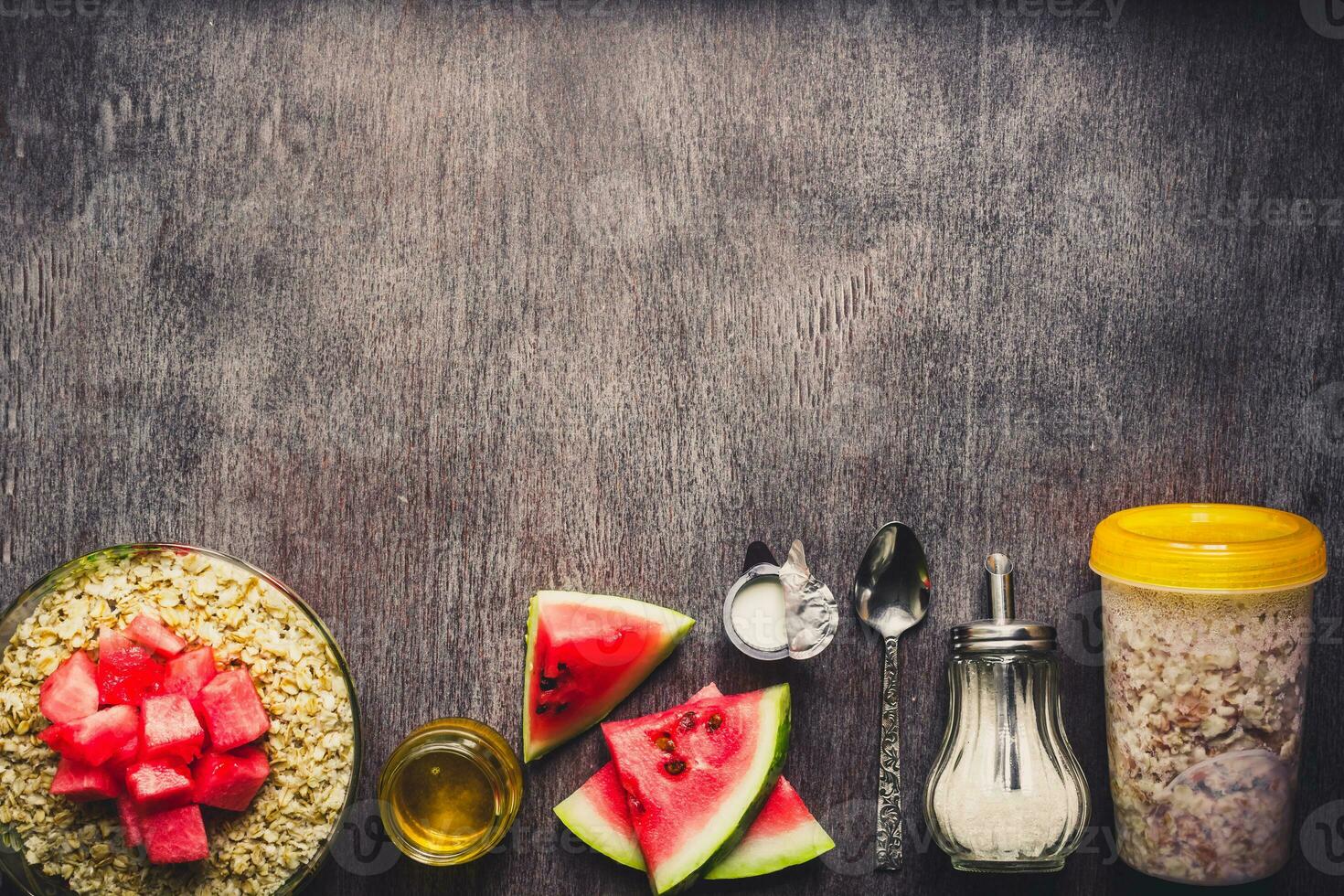 Ingredients for oatmeal on dark wooden table. Concept of healthy food. Top view, copy space. Toned photo