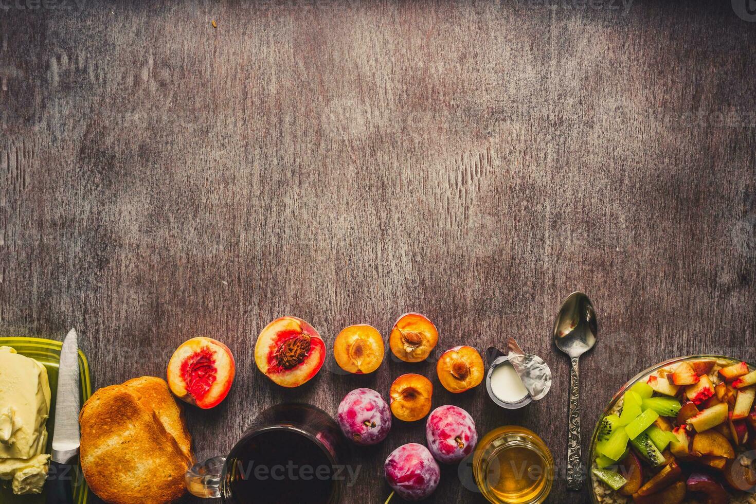 Healthy breakfast with oatmeal in a glass bowl and fruit on table. Toned photo