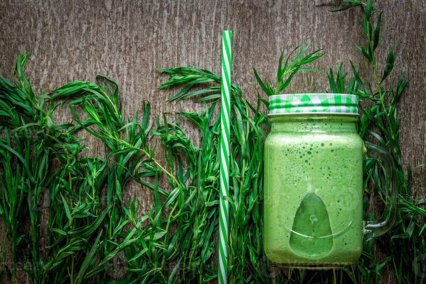 Glass of spinach juice on wooden background photo