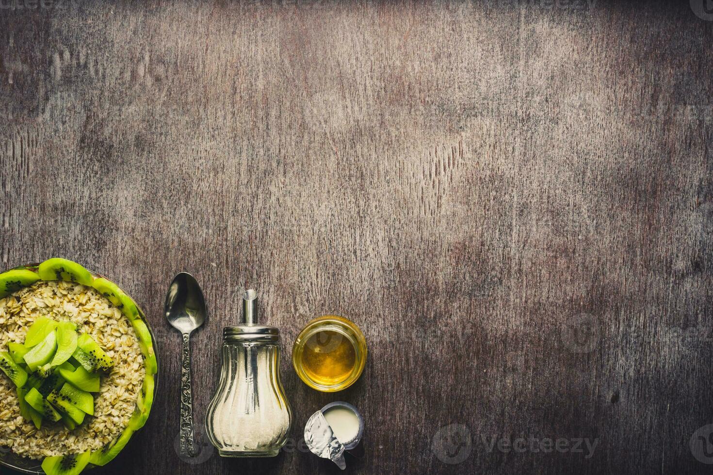 Healthy breakfast ingredients. Bowl of oat granola, fresh fruit and honey. Top view, copy space. Toned photo