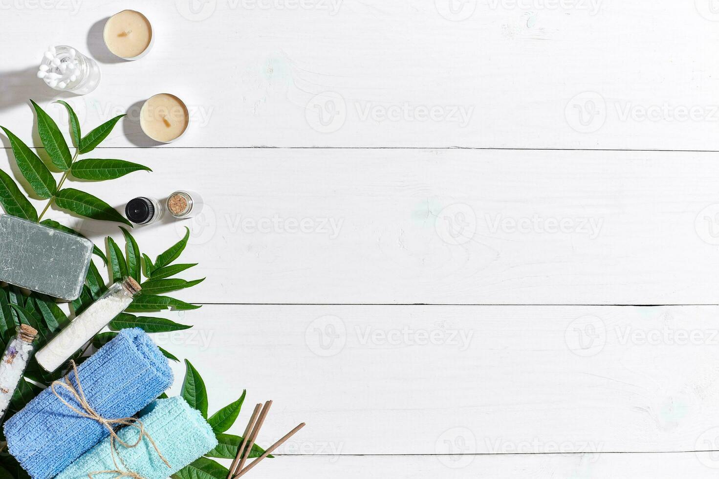 Spa set with towels and soap on white wooden background top view photo