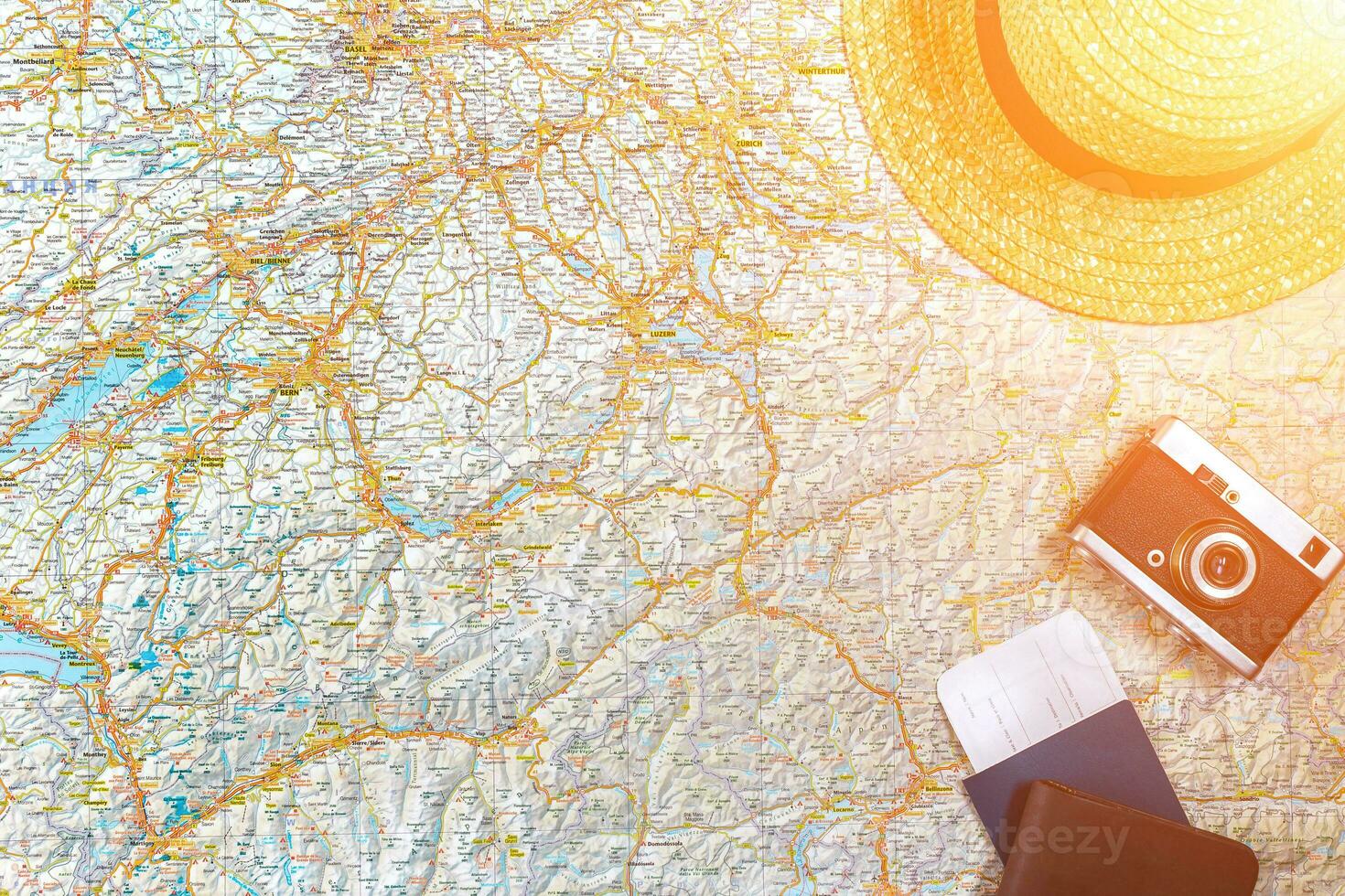 Map of roads with a vintage camera, passport, sunglasses. View from above. The concept of travel. Sun flare photo