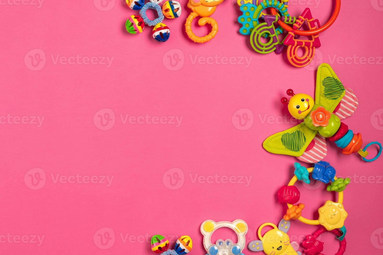 Children's rattle from plastic on a pink background. Top view photo