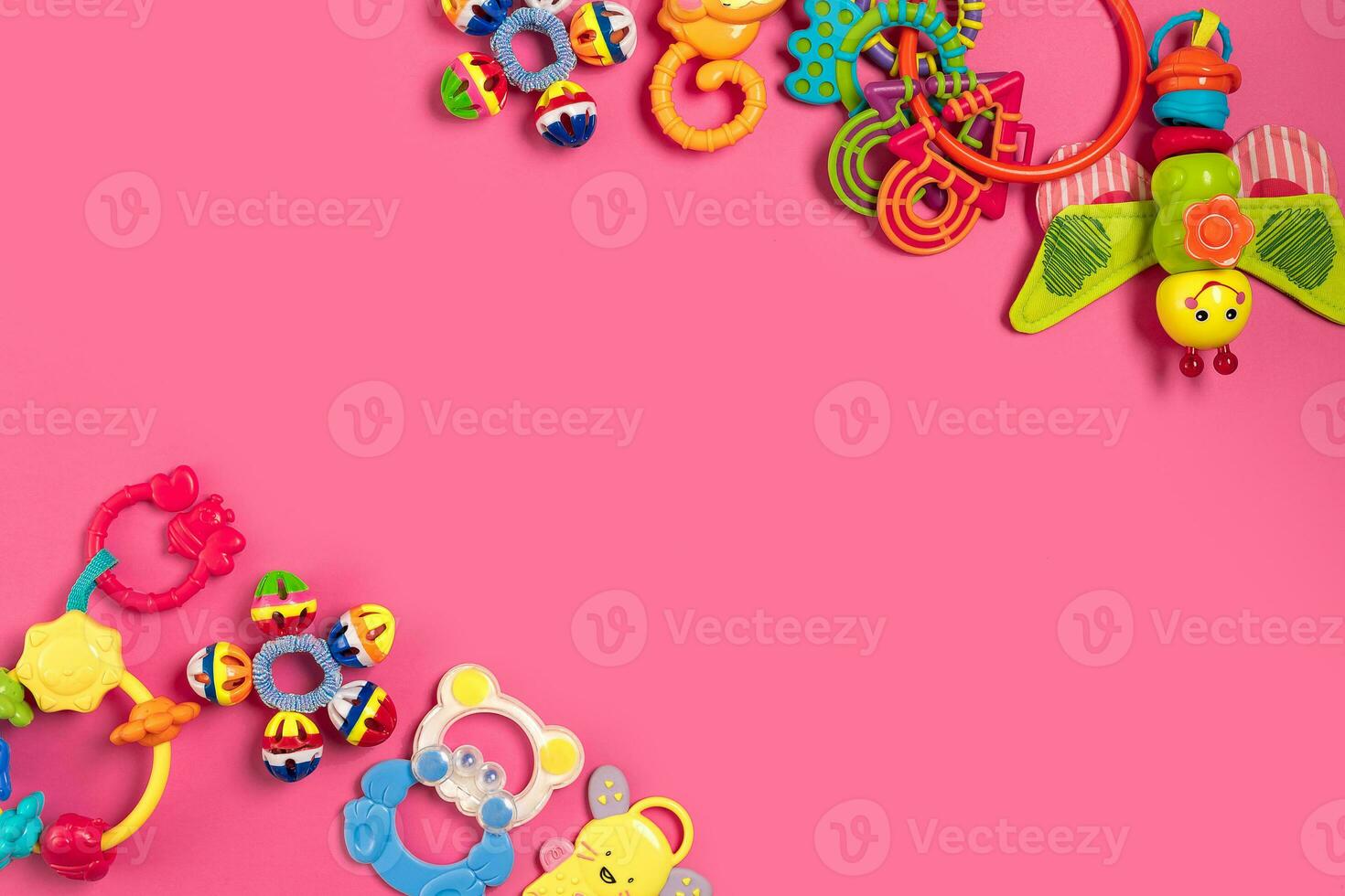 Children's rattle from plastic on a pink background. Top view photo