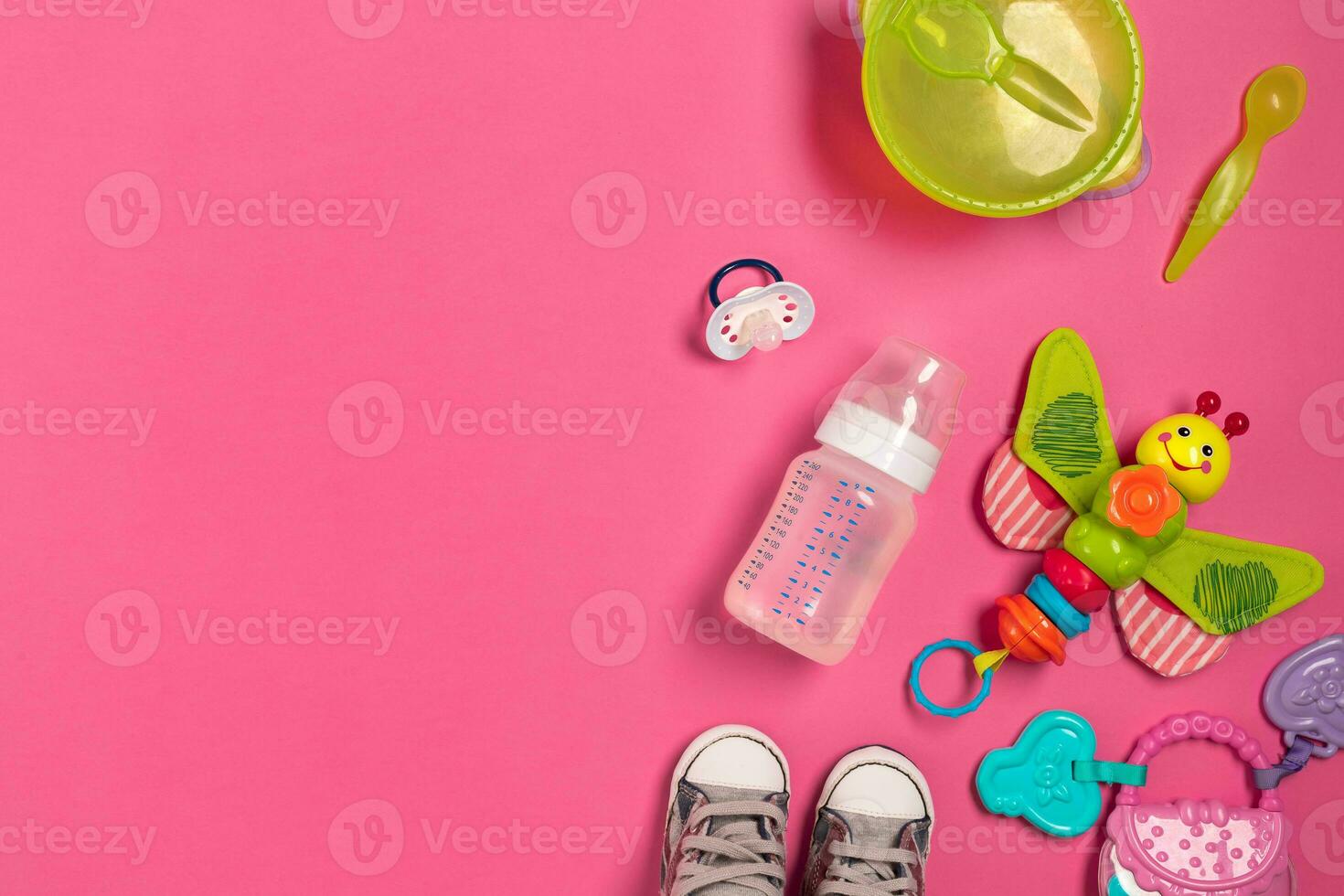 Baby toys and accessories on pink background. Top view photo