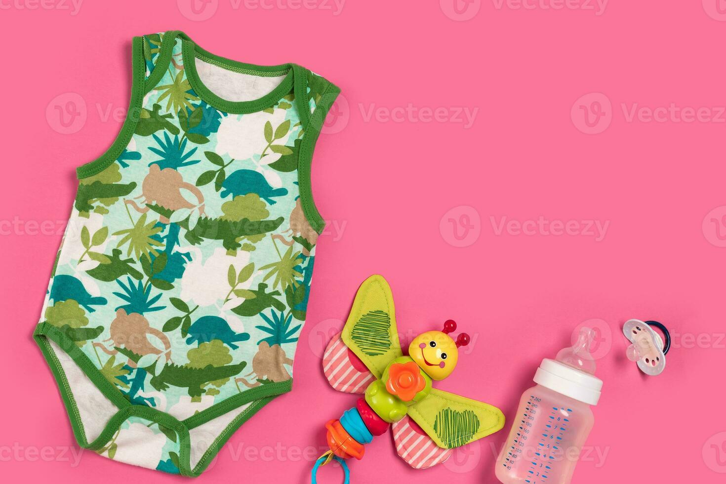 Baby clothes and accessories on pink background. Top view photo