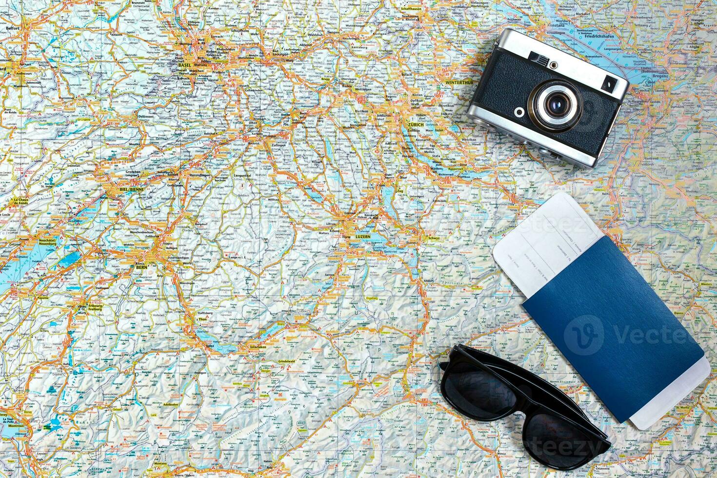 Map of roads with a vintage camera, passport, sunglasses. View from above. The concept of travel photo