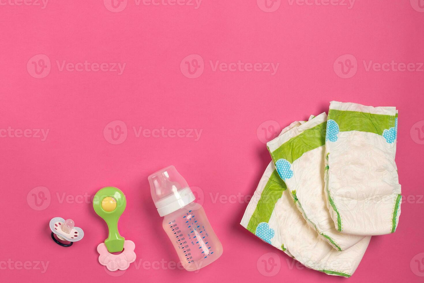 Baby care accessories and diapers on pink background. Top view photo