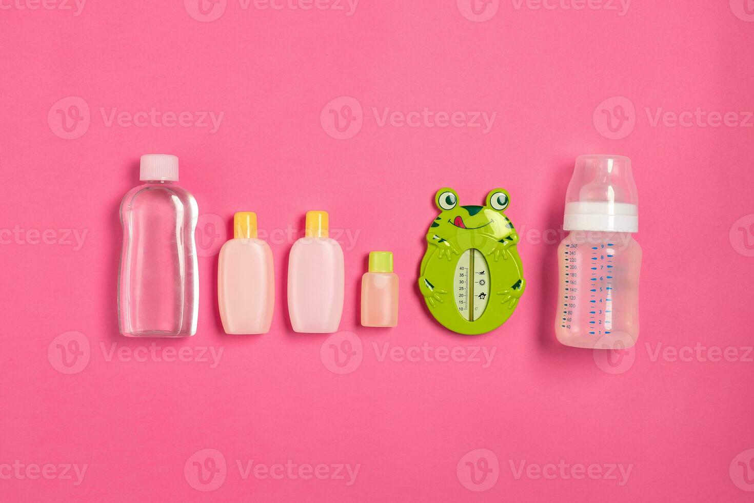 Baby accessories for bath with frog on pink background. Top view photo