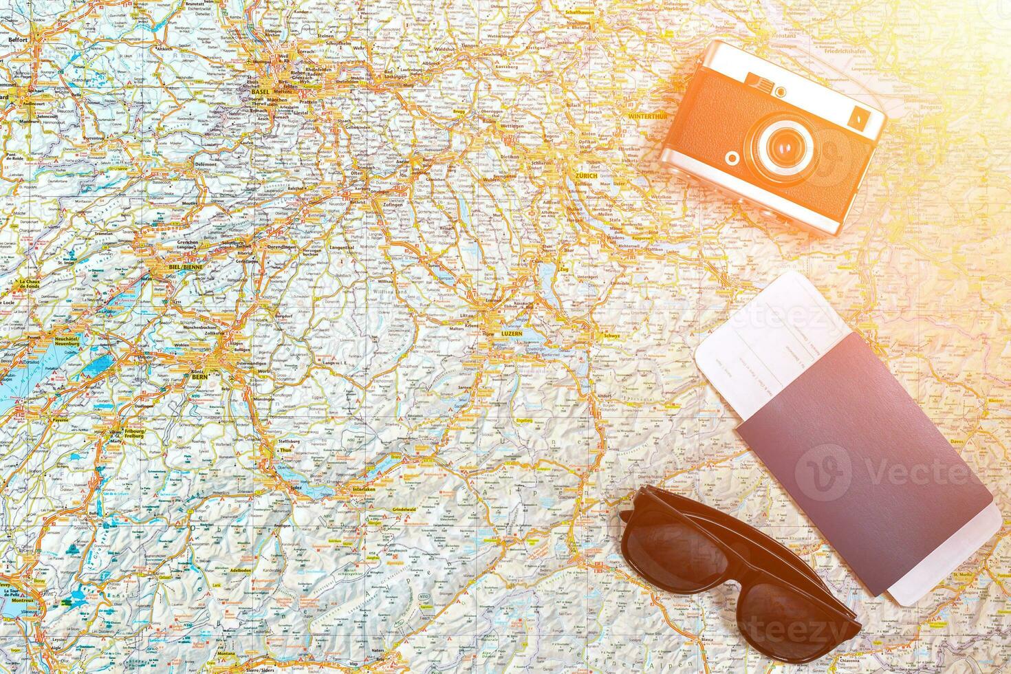 Map of roads with a vintage camera, passport, sunglasses. View from above. The concept of travel. Sun flare photo