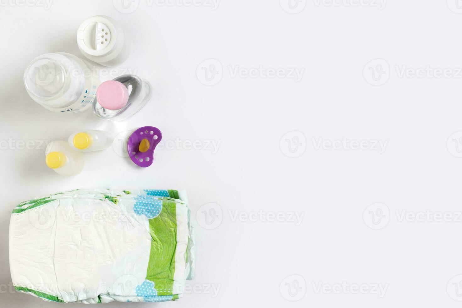 Babies goods diaper, baby powder, cream, shampoo, oil on white background with copy space. Top view or flat lay. photo