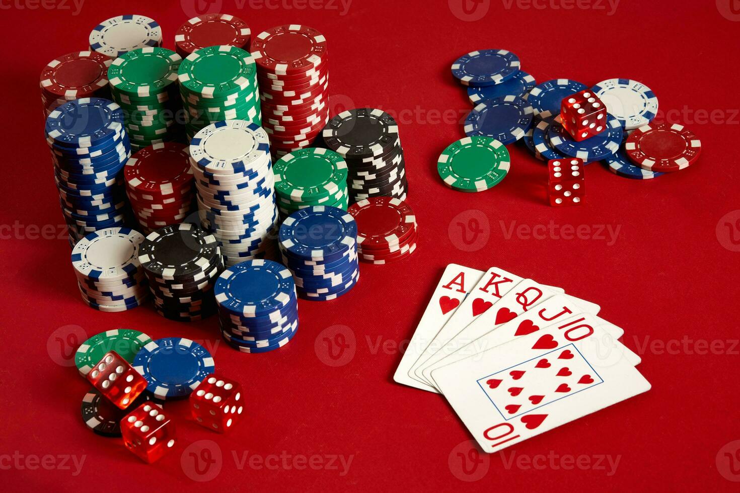 Casino gambling poker equipment and entertainment concept - close up of playing cards and chips at red background. Royal flush heart. photo