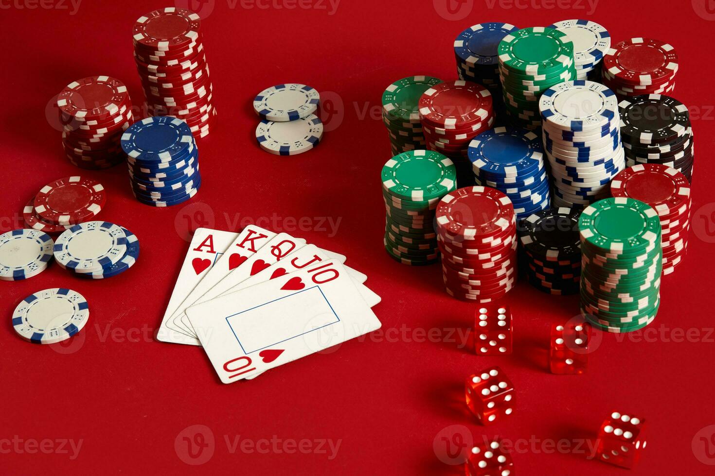 Casino gambling poker equipment and entertainment concept - close up of playing cards and chips at red background. Royal flush heart. photo