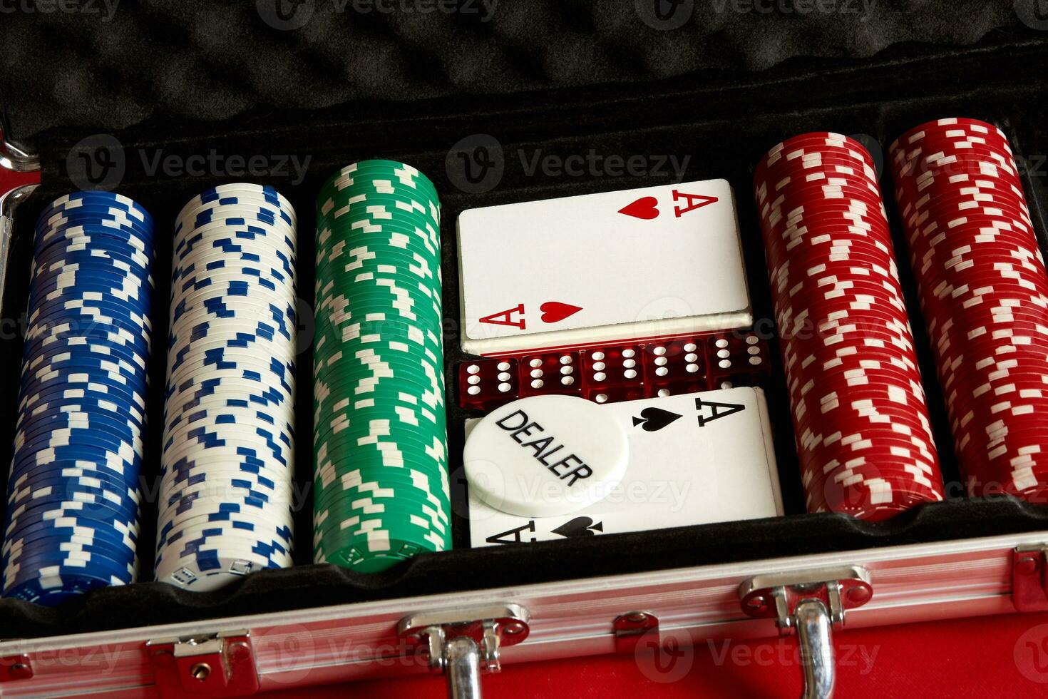 Poker set in metal suitcase. Risky entertainment of gambling. Top view on red background photo