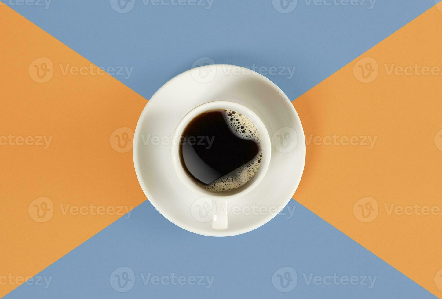 A cup of black coffee on orange and blue background. View from above. photo