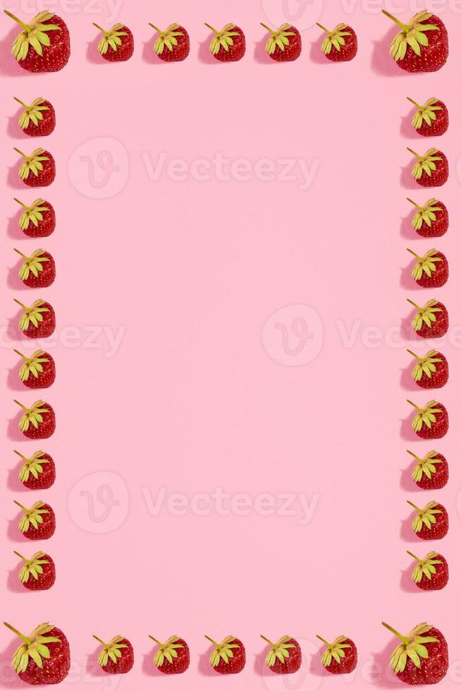 Colourful bright pattern with ripe strawberry. Top view. Pink background photo