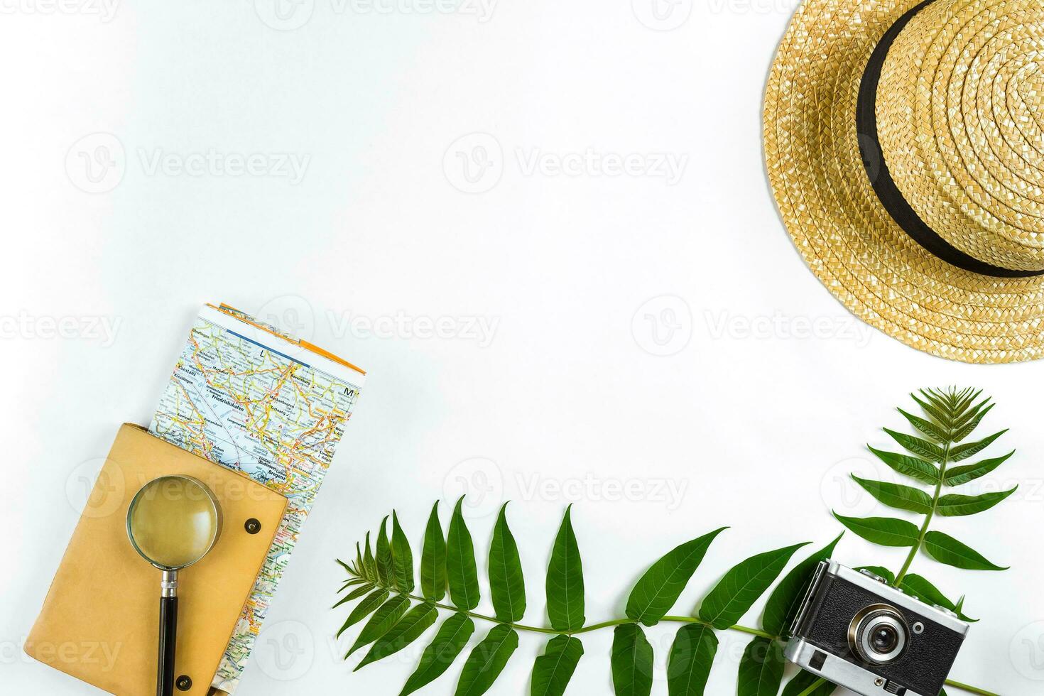 Straw hat with green leaves and old camera on white background, Summer background. Top view photo