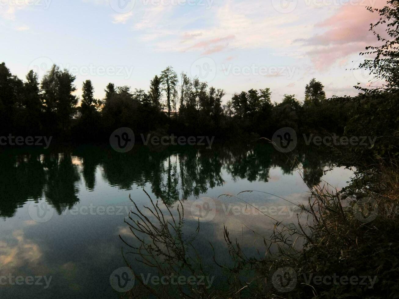 a lake with trees and sky reflected in it photo