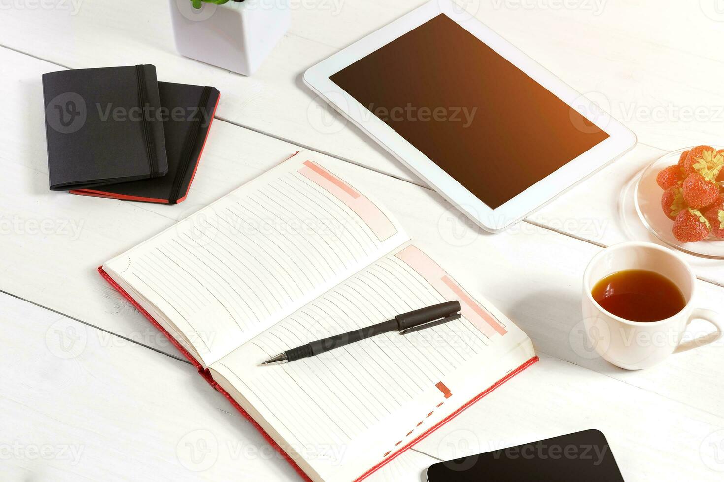 Stylish minimalistic workplace with tablet and notebook and glasses in flat lay style. White background. photo