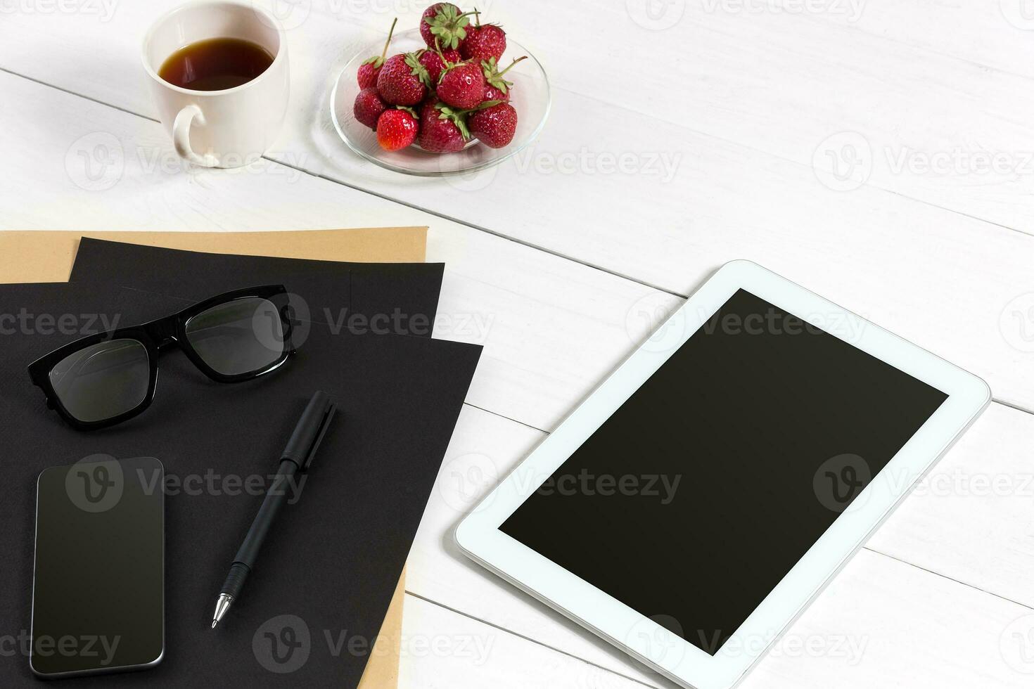 Tablet, blank sheet, glasses and coffee cup on office wooden table photo