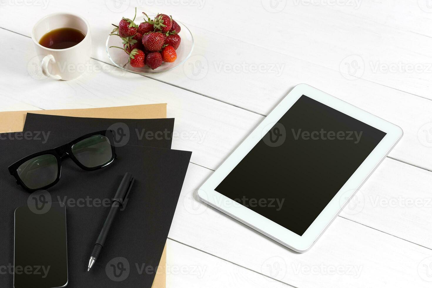 Modern workplace with digital tablet computer and mobile phone, cup of coffee, pen and empty sheet of paper. photo