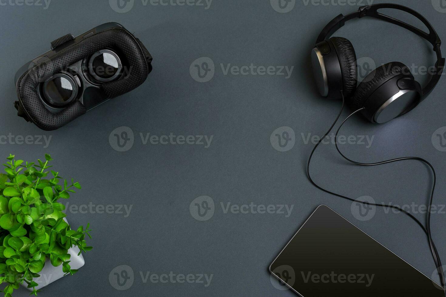Virtual reality glasses and tablet with headphones on a gray background. Top view photo