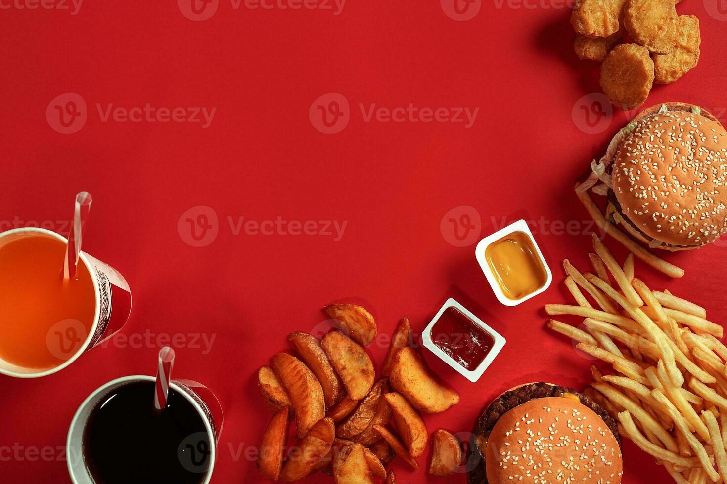 Fast food dish top view. Meat burger, potato chips and glass of drink on red background. Takeaway composition. photo