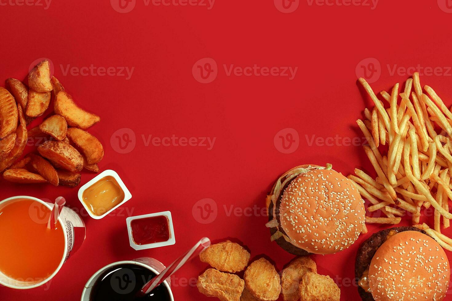 Fast food dish top view. Meat burger, potato chips and glass of drink on red background. Takeaway composition. photo