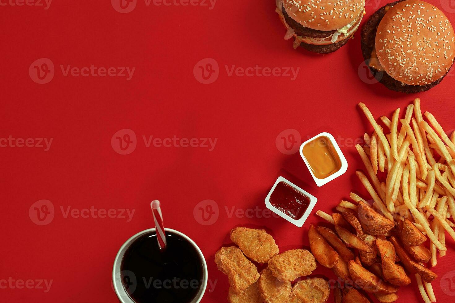 Fast food dish top view. Meat burger, potato chips and glass of drink on red background. Takeaway composition. photo