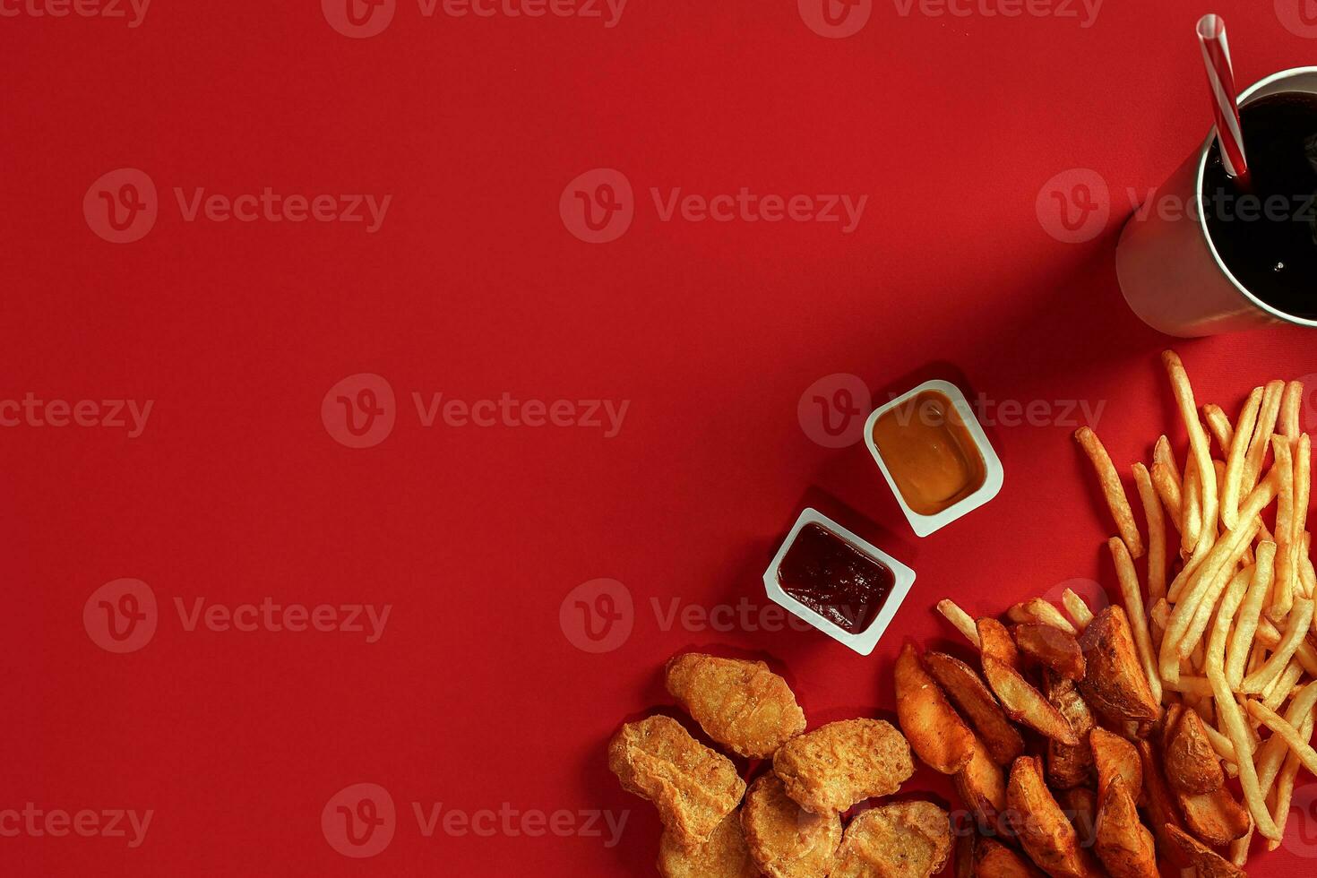 Fast food dish top view. Meat burger, potato chips and glass of drink on red background. Takeaway composition. photo