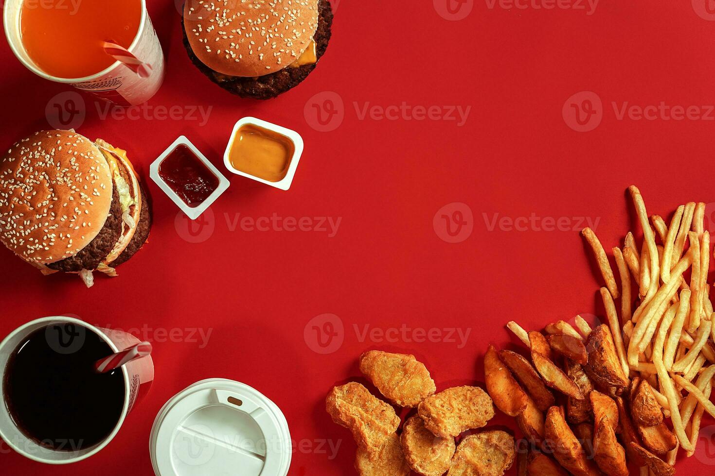 Fast food dish top view. Meat burger, potato chips and glass of drink on red background. Takeaway composition. photo