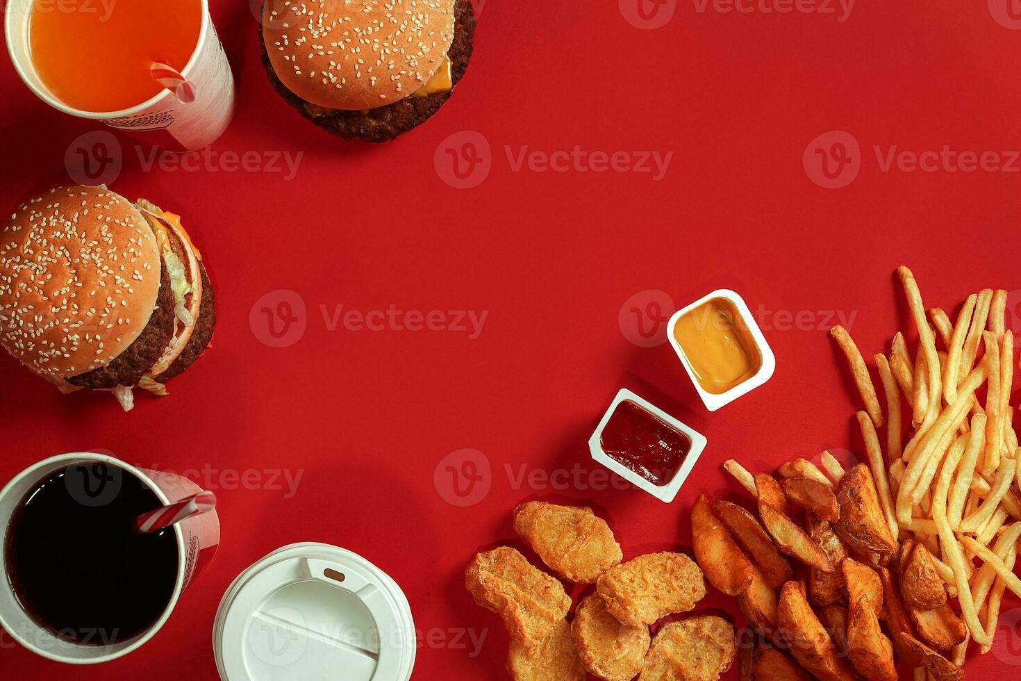 Fast food dish top view. Meat burger, potato chips and glass of drink on red background. Takeaway composition. photo