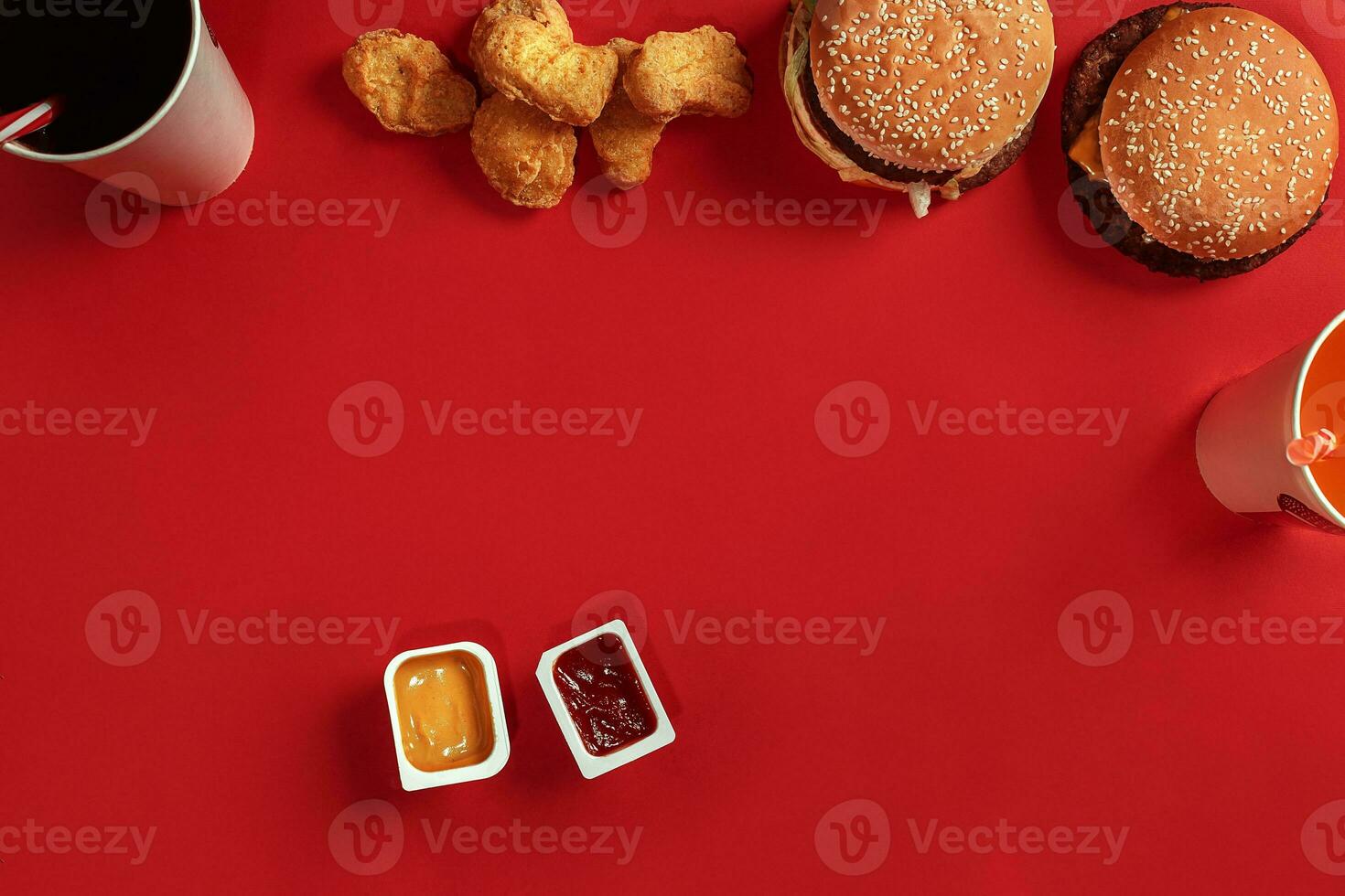 Fast food dish top view. Meat burger, potato chips and glass of drink on red background. Takeaway composition. photo