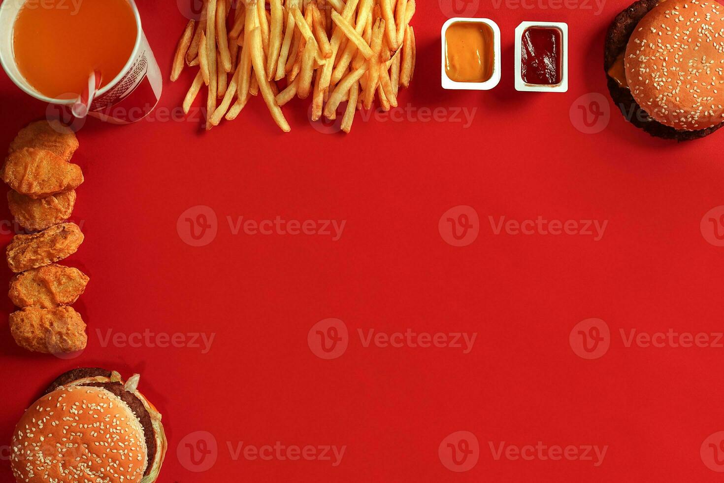 Fast food dish top view. Meat burger, potato chips and glass of drink on red background. Takeaway composition. photo