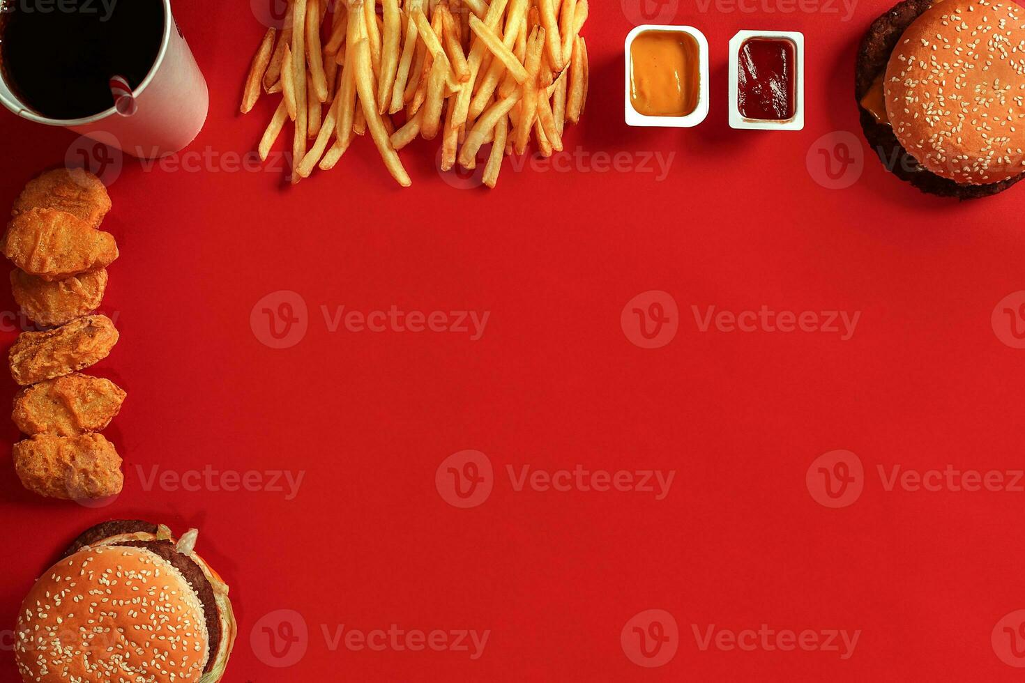 Fast food dish top view. Meat burger, potato chips and glass of drink on red background. Takeaway composition. photo