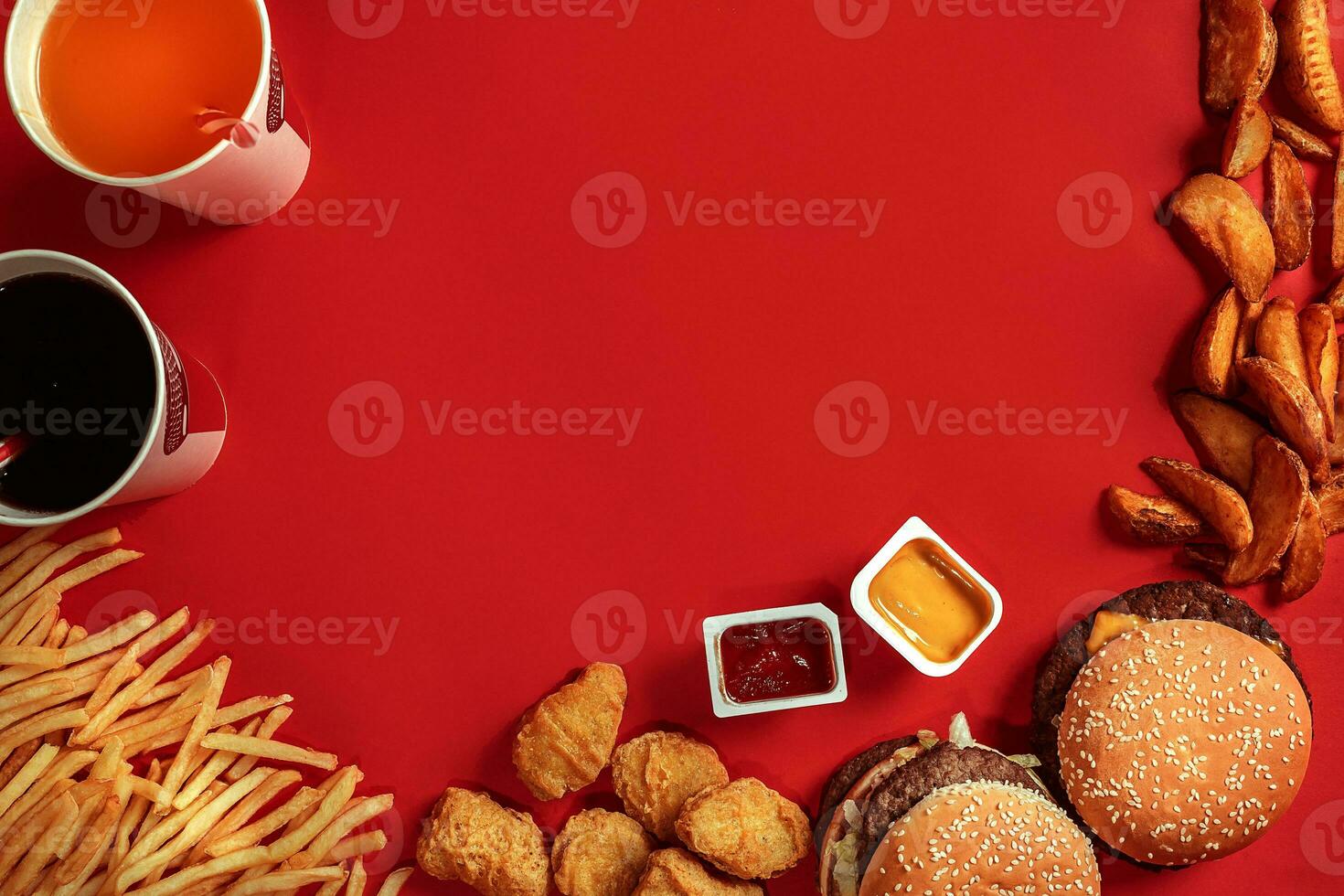 Fast food dish top view. Meat burger, potato chips and glass of drink on red background. Takeaway composition. photo