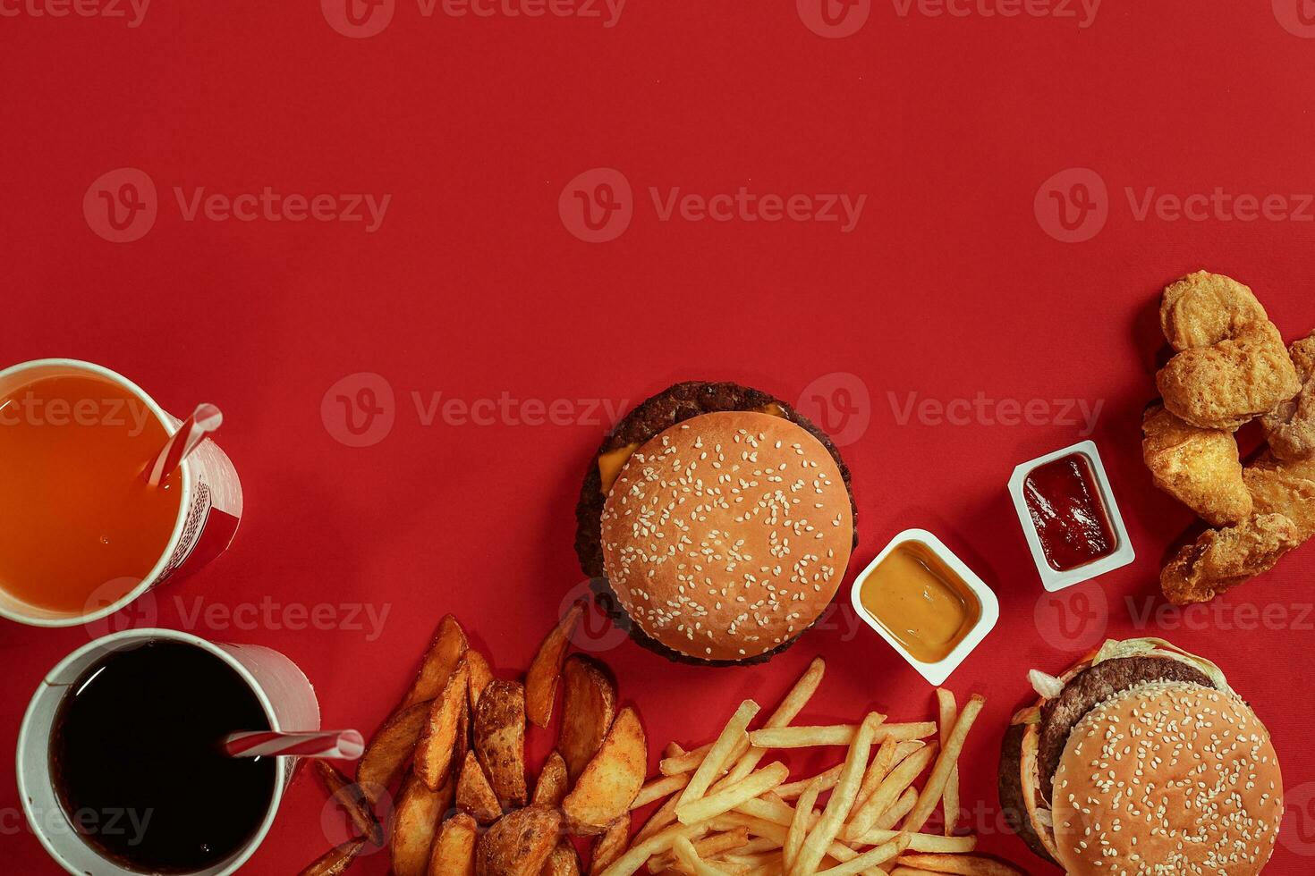 Fast food dish top view. Meat burger, potato chips and glass of drink on red background. Takeaway composition. photo