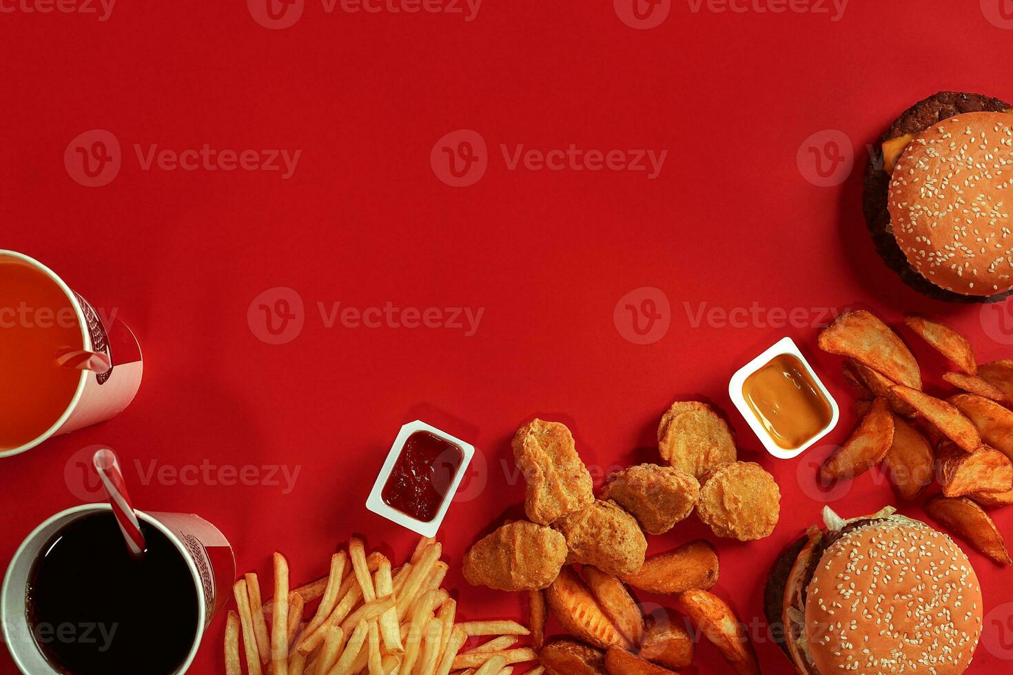 Fast food dish top view. Meat burger, potato chips and glass of drink on red background. Takeaway composition. photo