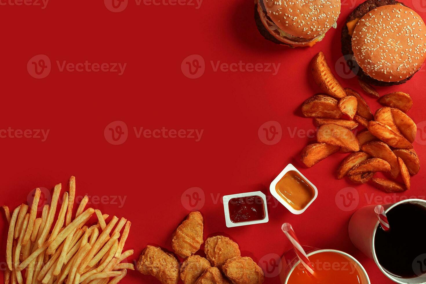 Fast food dish top view. Meat burger, potato chips and glass of drink on red background. Takeaway composition. photo