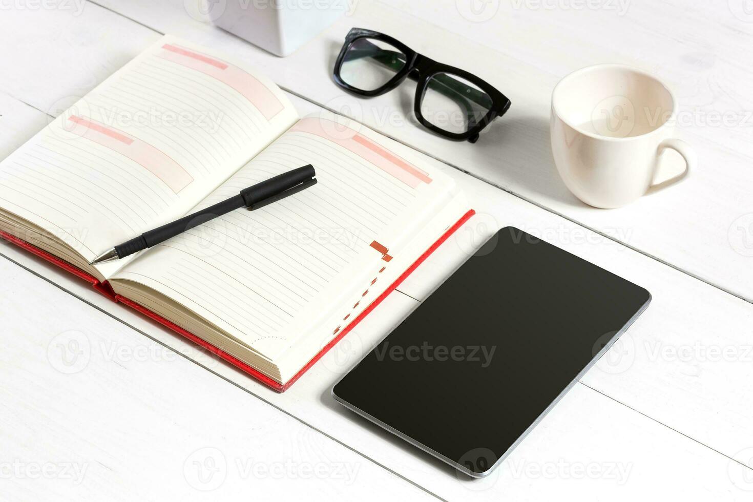 Stylish minimalistic workplace with tablet and notebook and glasses in flat lay style. White background. photo