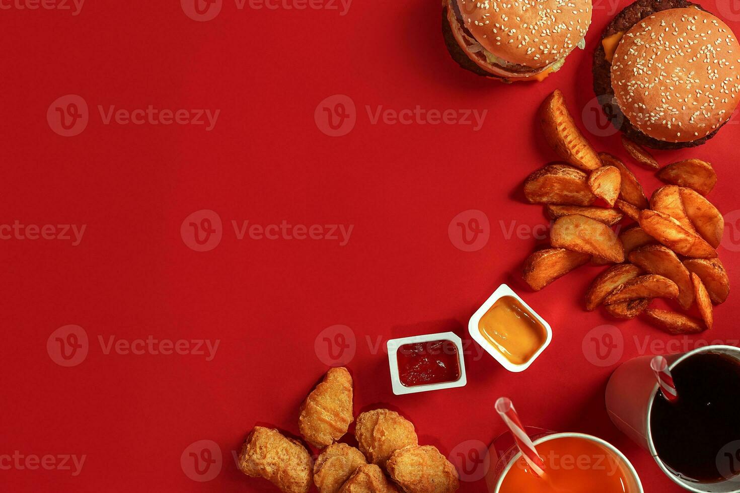 Fast food dish top view. Meat burger, potato chips and glass of drink on red background. Takeaway composition. photo