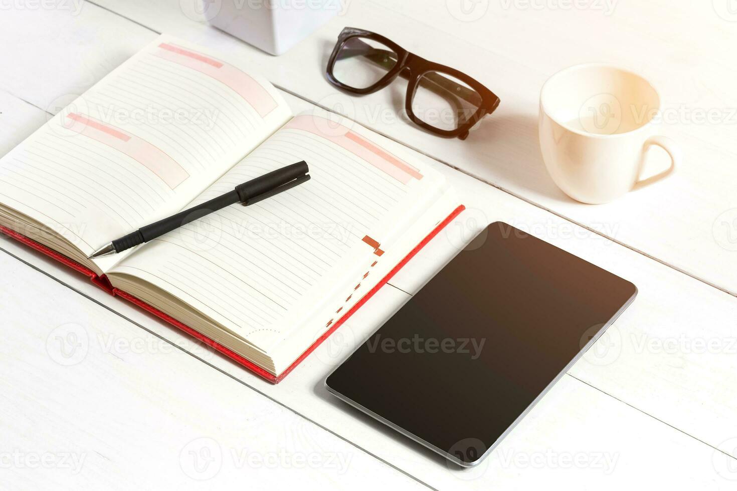 Stylish minimalistic workplace with tablet and notebook and glasses in flat lay style. White background. photo
