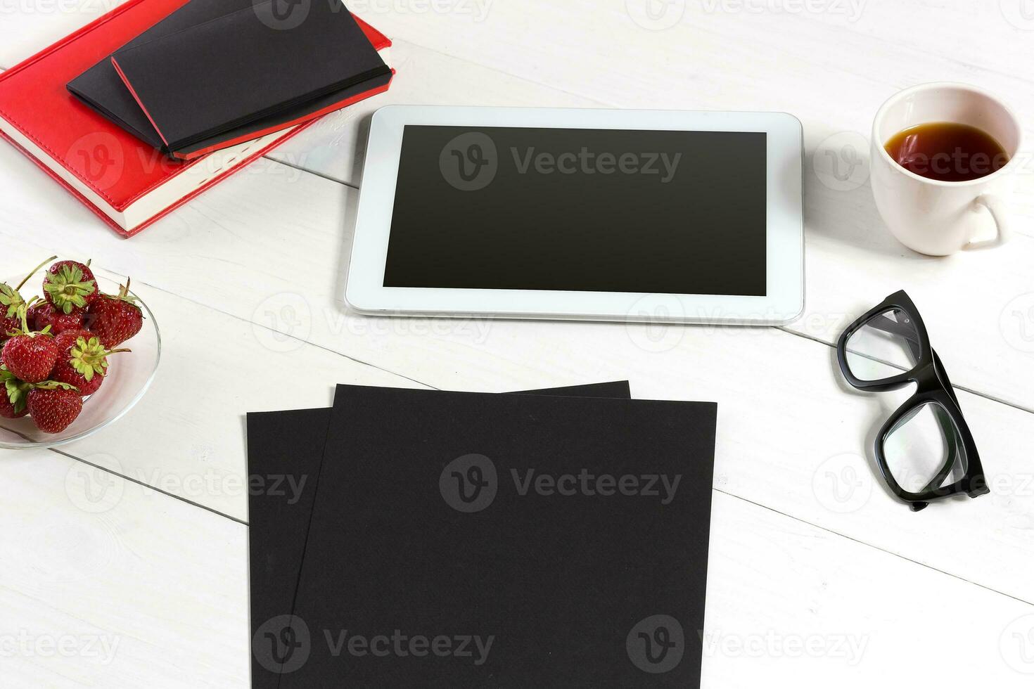 Stylish minimalistic workplace with tablet and notebook and glasses in flat lay style. White background. photo