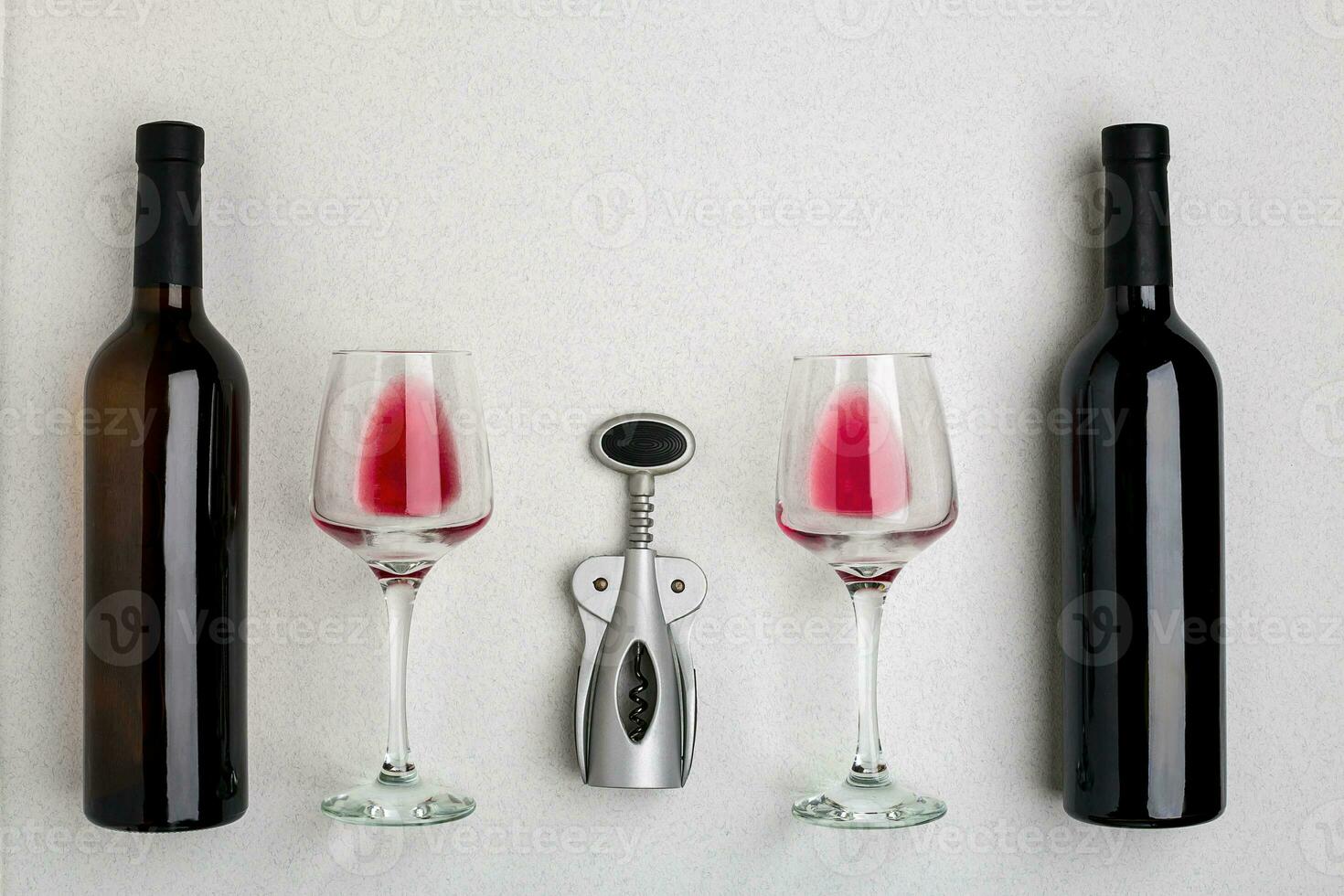 Glasses and bottles of red and white wine on white background from top view photo