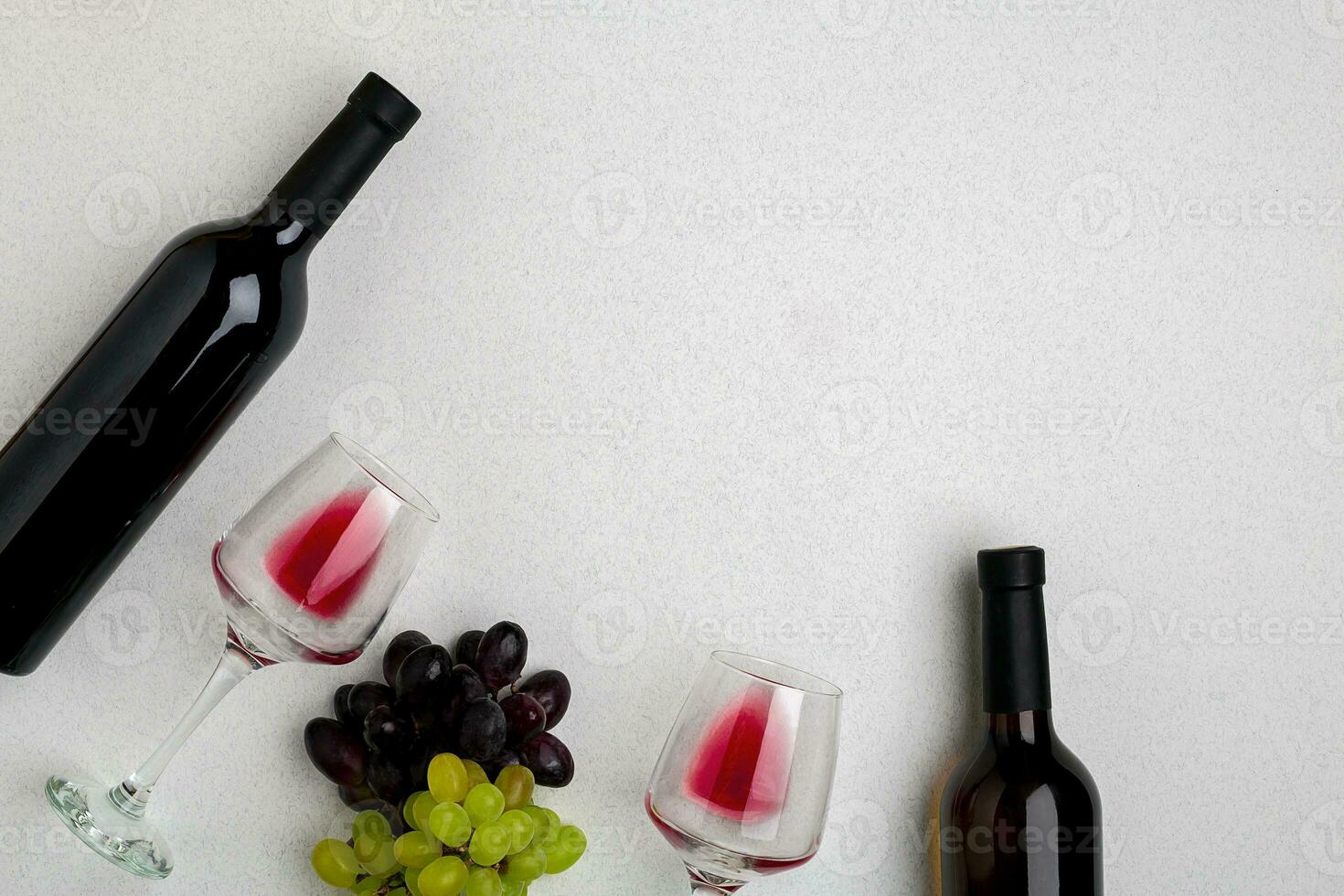 Glasses and bottles of red and white wine on white background from top view photo