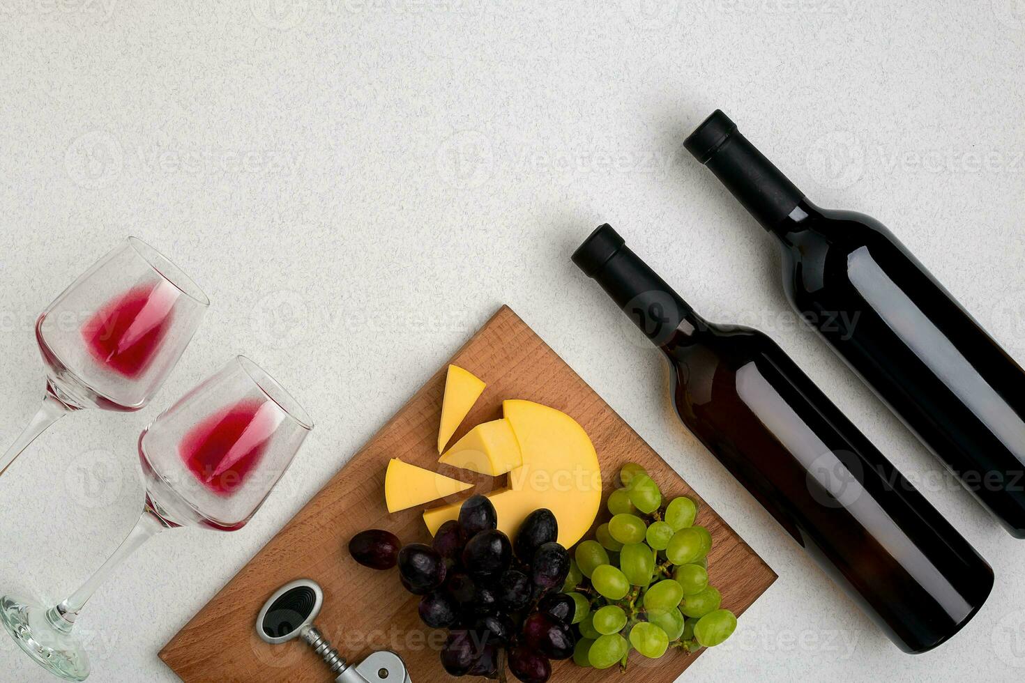 Two glasses of red wine, cheese and grapes. Top view photo
