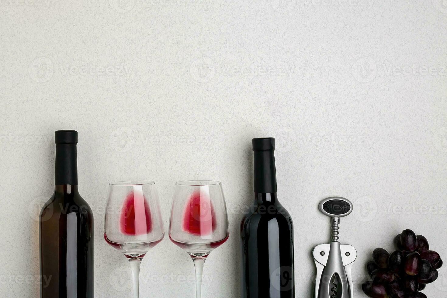 Glasses and bottles of red and white wine on white background from top view photo