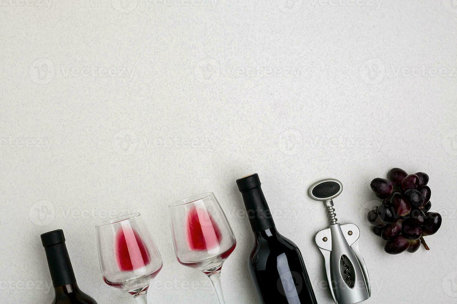 Glasses and bottles of red and white wine on white background from top view photo